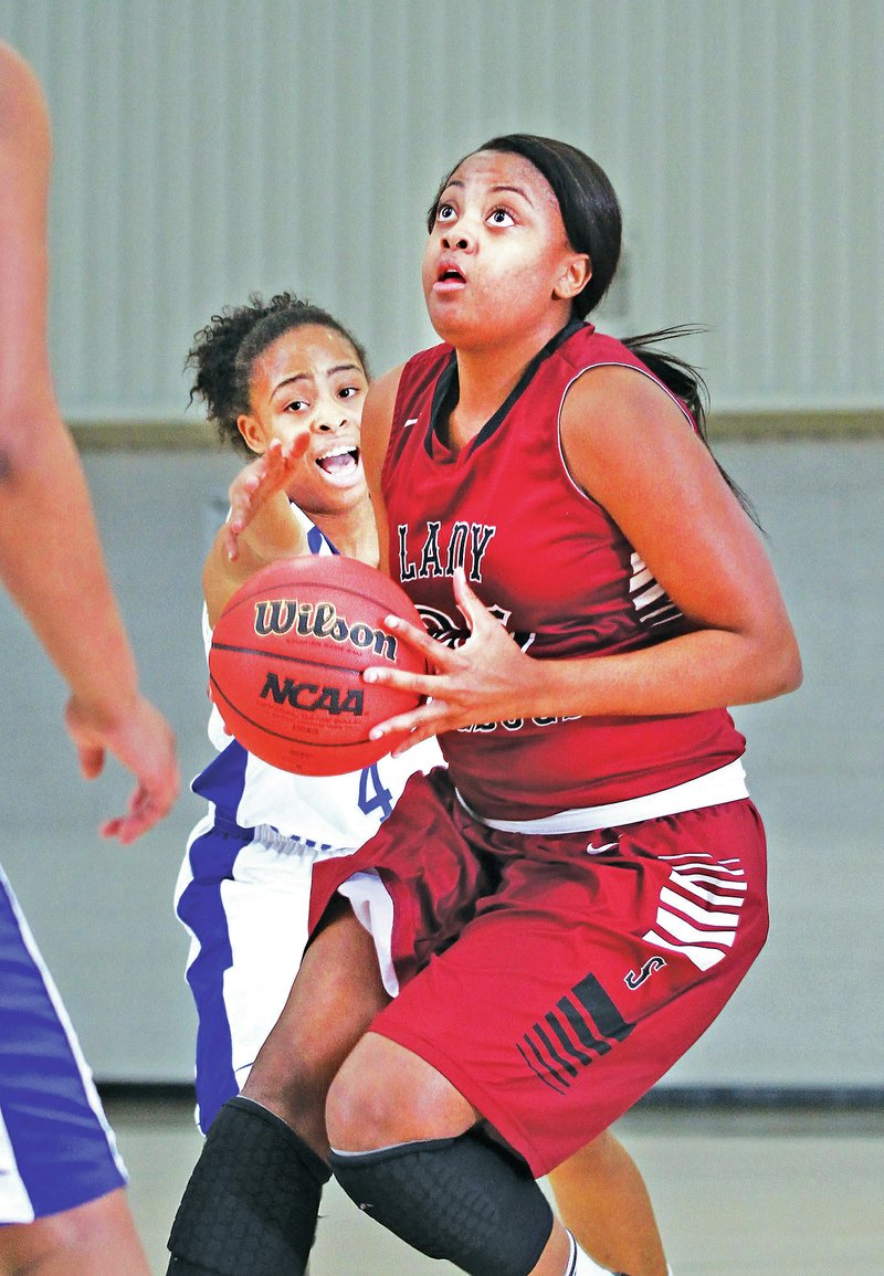 SPECIAL TO NWA MEDIA SAMANTHA BAKER Desiree Mack of Springdale High drives to the hoop Monday in front of Forrest City&#8217;s Tamira Ray during the 60th annual Neosho Holiday Classic at Neosho Middle School in Missouri.