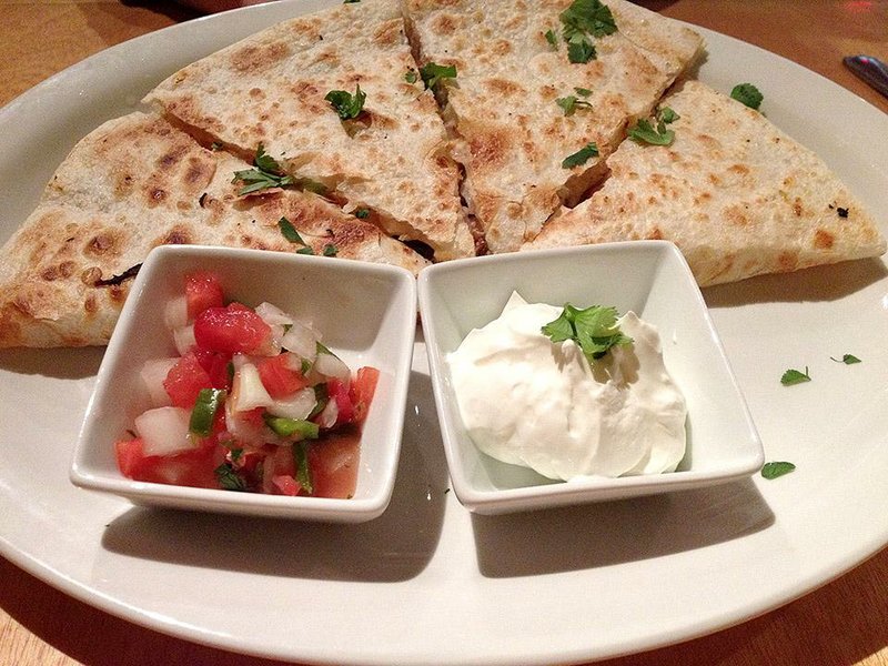 Baja Grill’s Pig Sooie quesadilla is filled with shredded pork, barbecue sauce, cheddar cheese, Southern slaw and pickled red onions, served with pico de gallo and sour cream. 