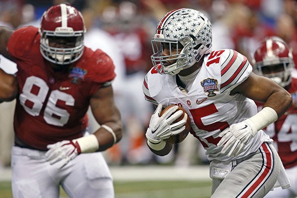 Ohio State running back Ezekiel Elliott (15) runs toward the end zone as Alabama defensive lineman A'Shawn Robinson (86) looks on in the second half of the Sugar Bowl NCAA college football playoff semifinal game, Thursday, Jan. 1, 2015, in New Orleans. Elliott scored a touchdown on the play. (AP Photo/Bill Haber)