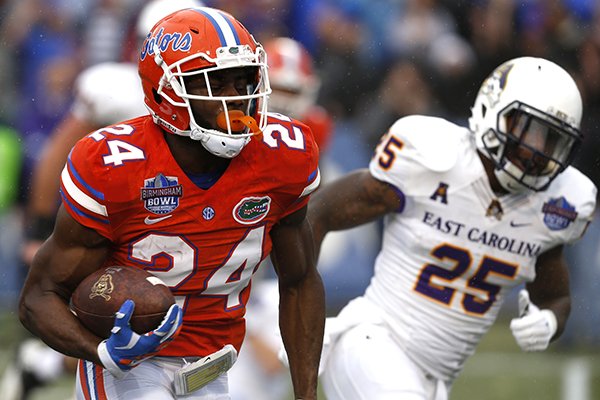 Florida defensive back Brian Poole (24) returns an interception for a touchdown during the first half of an Birmingham Bowl NCAA college football game against East Carolina Saturday, Jan. 3, 2015, in Birmingham, Ala. (AP Photo/Butch Dill)