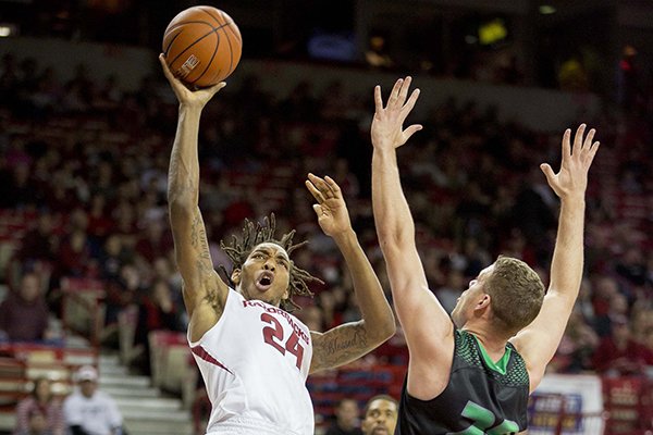 Arkansas guard Michael Qualls, left, pulls back for a jump shot as Utah Valley forward Brenden Evans, right, defends during the second half of an NCAA college basketball game on Saturday, Jan. 3, 2015, in Fayetteville, Ark. Arkansas defeated Utah Valley 79-46. (AP Photo/Gareth Patterson)