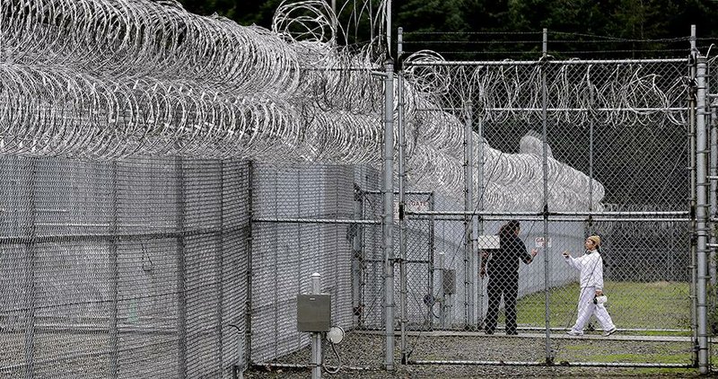 In this photo taken Oct. 17, 2014, a correctional officer, left, directs an offender through a gate at the Washington Corrections Center For Women in Gig Harbor, Wash. A 2003 federal law was meant to put a stop to sexual assault in the nation’s prisons, jails and juvenile detention centers and more than $110 million in state and federal taxpayer money has been spent to help states tackle the problem. By last fall, every state was supposed to have dozens of new standards in place, ranging from increased training of staff about sex abuse policies to procedures meant to help inmates safely report attacks. (AP Photo/Elaine Thompson)