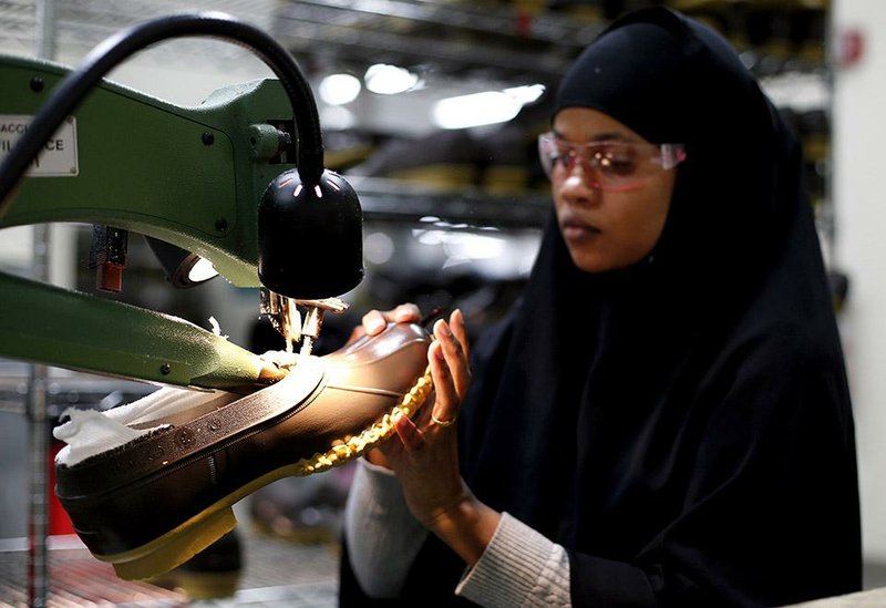 An L.L. Bean employee trims the rubber bottom of a boot last month in Lewiston, Maine. A report Wednesday said private companies added 241,000 jobs in December. 