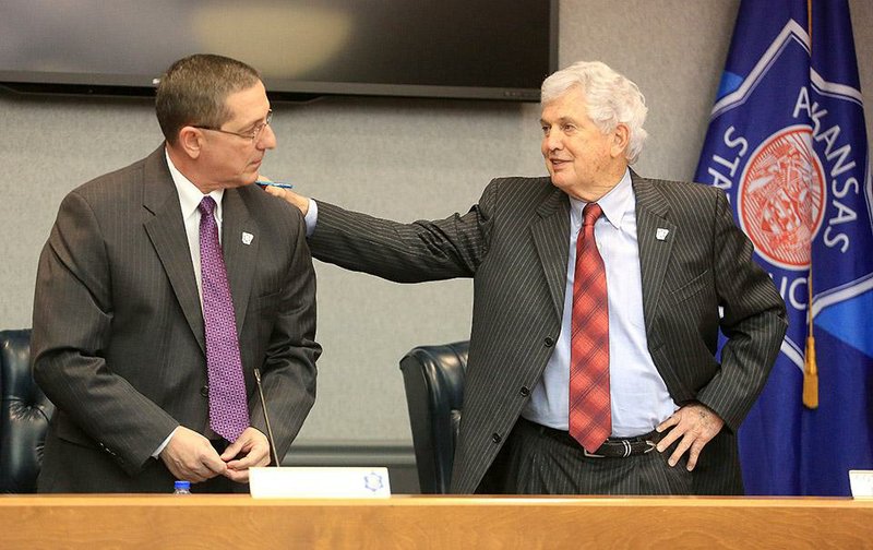 Outgoing Arkansas State Police Director Col. Stan Witt (left) and outgoing Arkansas State Police Commission Chairman Woody Futrell chat after announcing that Witt will finish his career as a major and Futrell is leaving the commission after 22½ years during a meeting of the commission in Little Rock on Wednesday. 