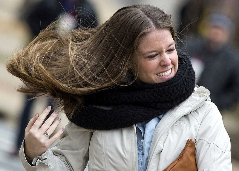 Sarah Ingle adjusts her hair in the strong winds off Sixth Street in Little Rock on Wednesday. 