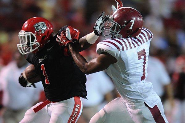 Fort Smith Northside running back Justin Curry (1) reaches to fend off Pine Bluff linebacker Keshawn Whaley during the first half Friday, Sept. 5, 2014, at Mayo-Thompson Stadium in Fort Smith.