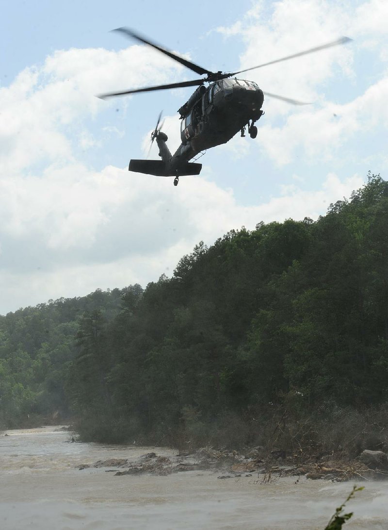 An Army National Guard helicopter searches the Fourche La Fave River near Y City after heavy rains in May 2013.