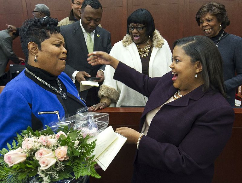 Colette Honorable (right) is congratulated Friday by her sister, Pamela Smith, after Honorable’s investiture at the federal courthouse in Little Rock as the newest member of the Federal Energy Regulatory Commission. 