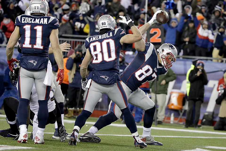 New England Patriots wide receiver Julian Edelman (11) holds up the  football after scoring a touchdown against the Denver Broncos