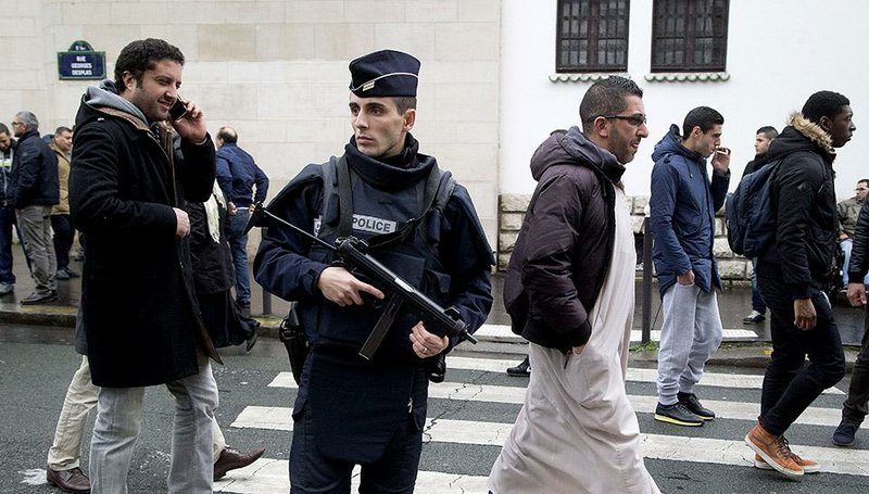 A French policeman keeps watch Friday outside the Grand Mosque in Paris as Muslims arrive for prayers. “The Muslim community is very afraid,” Hassen Farsadou, the president of the Union of Muslim Associations of Seine-Saint-Denis, said Saturday. 
