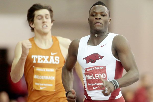 Arkansas freshman Omar McLeod leads Texas sophomore Zack Bilderback to the finish line in the 200-meter dash during a dual meet against Texas on Friday, Jan. 17, 2014, at the Randal Tyson Track Center in Fayetteville.
