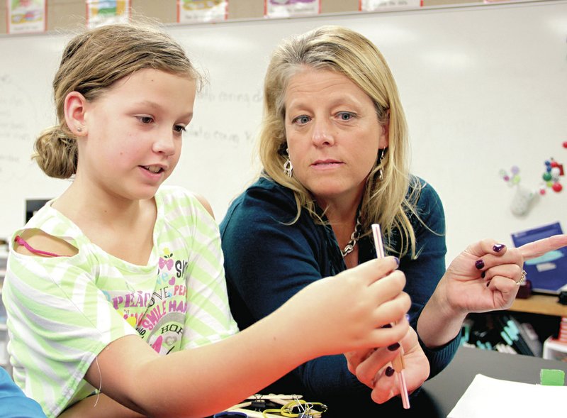 LYNN KUTTER ENTERPRISE-LEADER Fifth-grade Farmington science teacher Linda Flynn talks with Parker Safely about her group&#8217;s project to create a potato coring device to take a sample from a potato slice. Flynn is one of three finalists to represent Arkansas for a math and science excellence award.