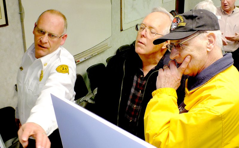 Brandon Howard/The Weekly Vista Bella Vista Fire Chief Steve Sims, far left, discuss a proposed rendering for the city&#8217;s fourth fire station with Doug Farner, center, and Michael Hickey Jan. 7 inside the Fire Department Training Room at Station No. 1.