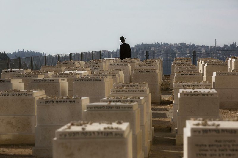 An ultra-Orthodox Jewish man walks in a cemetery in Jerusalem on Tuesday during the funeral of four Jewish victims of the Jan. 9 attack on a kosher grocery store in Paris. 