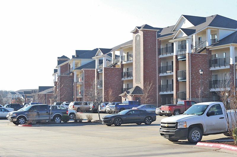 NWA Democrat-Gazette/ANDY SHUPE Cars fill the parking lot Thursday at The Links at Fayetteville. Lindsey Management plans to add 456 apartments and 39 single-family lots as the second phase of development.