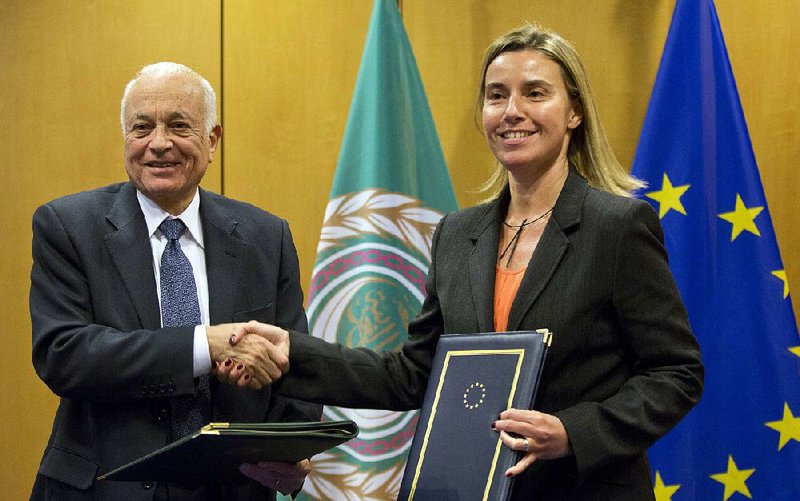 Secretary General of the Arab League Nabil Al-Araby, left, shakes hands with European Union High Representative Federica Mogherini after signing a cooperation agreement after a meeting of EU foreign ministers in Brussels on Monday, Jan. 19, 2015. The European Union is calling for an anti-terror alliance with Arab countries to boost cooperation and information sharing in the wake of deadly attacks and arrests across Europe linked to foreign fighters. (AP Photo/Virginia Mayo)