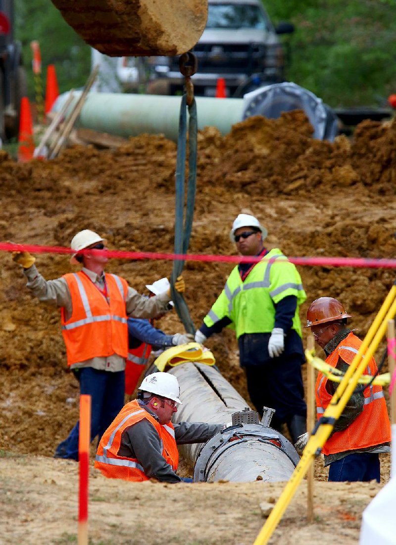 4/15/13
Arkansas Democrat-Gazette/STEPHEN B. THORNTON
Exxon Mobile Pipeline workers begin to lift out the damaged section of the Pegasus pipeline Monday morning in Mayflower's Northwood subdivision. The 22 foot long crack can be seen on the top of the pipe.