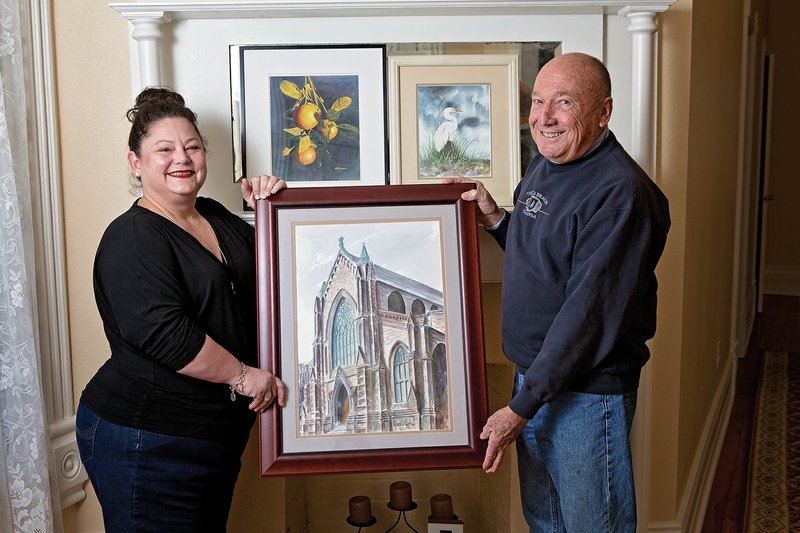 Dee Sanders, left, co-chairwoman of the Art, Pray, Love: Teaching Hearts, Changing Lives fundraiser, and Conway artist Bill Eshelman hold one of the paintings that will be on display during the Jan. 31 event, which will be held at St. Peter’s Episcopal Church and The Morgan House in Conway.