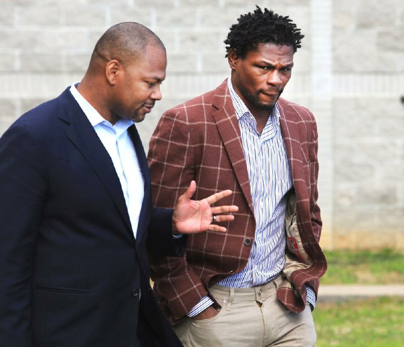 IBF middleweight boxing champion Jermain Taylor (right) walks with attorney S.L. Smith on Tuesday. Taylor pleaded innocent to drug and gun charges Tuesday.