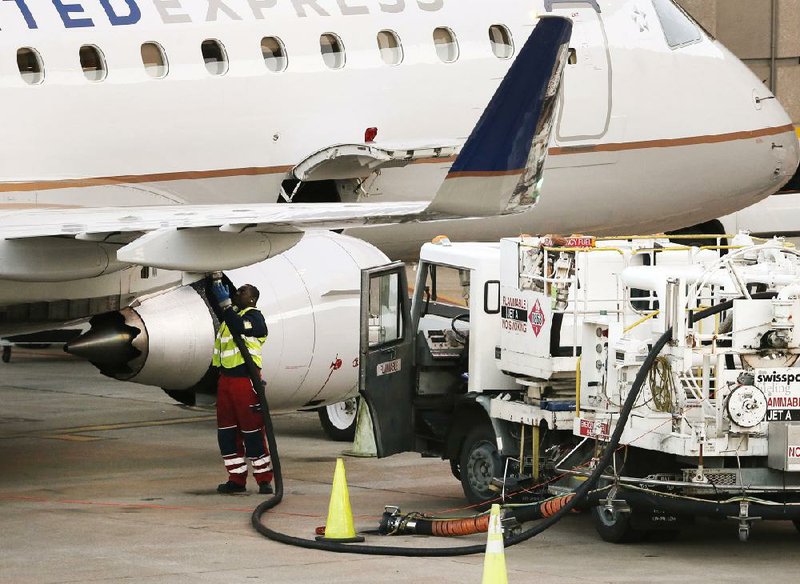 A worker fuels a United Express jetliner Thursday at Dallas-Fort Worth International Airport. Despite falling prices for jet fuel, analysts say airlines have no incentive to lower airfares.