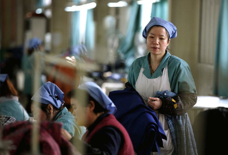 Women work at a garment factory Tuesday in Huaibei in central China’s Anhui province. 