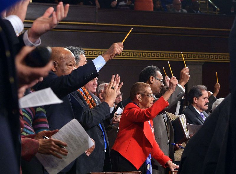In a symbol of free speech and a show solidarity with victims of the attack on the satirical French publication Charlie Hebdo, lawmakers hold up pencils Tuesday evening after President Barack Obama said America stood with the people of Paris. Republicans and Democrats alike rose to applaud the statement. 