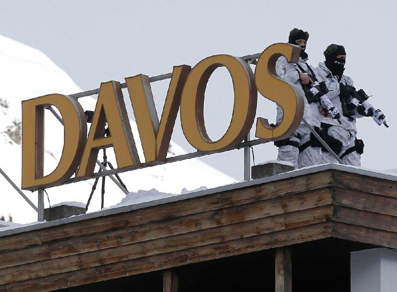 Swiss police stand guard on the roof of a hotel Tuesday in Davos, Switzerland. Members of the World Economic Forum begin their annual meeting today at the Alpine ski resort. 