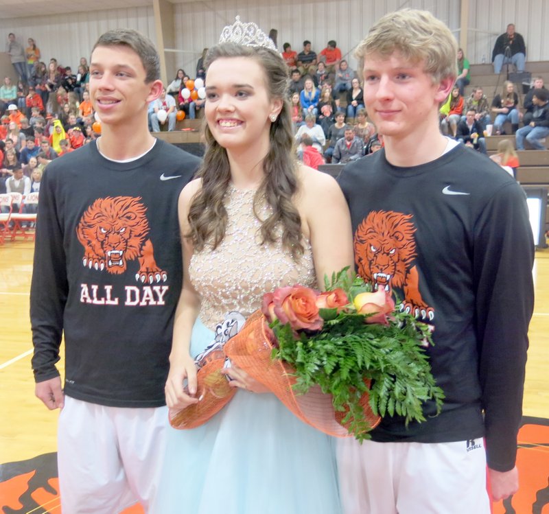 Photo by Susan Holland Maddie Foster was all smiles as she posed with her beautiful bouquet and was introduced to the crowd following her coronation as basketball homecoming queen Friday night. She was accompanied by her escorts, Zac Carlton and Jonathan Reister, who seemed to be pretty pleased themselves. All three are seniors at Gravette High School.