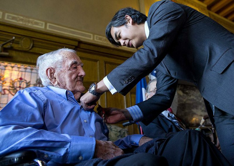 Sujiro Seam, the consul general of France in Houston, pins World War II veteran Tommy Gooch, 100, with the medal of Knight in the French Order of the Legion of Honor on Wednesday during a ceremony at the state Capitol. The medal is France’s highest military distinction. 