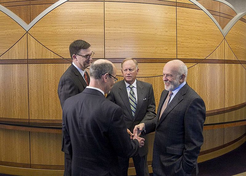 John Tyson (right) talks Wednesday in Little Rock with University of Arkansas System administrators (from left) Michael Moore, vice president of academic affairs, Donald Bobbitt, president of the UA System, and Jim von Gremp, chairman of the UA board of trustees, after the Tysons’ $500,000 donation to the UA eVersity was announced. 