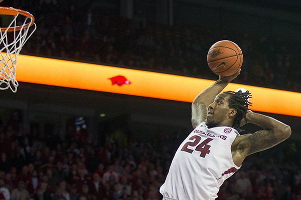 Arkansas guard Michael Qualls, right, leaps for a one-handed dunk during overtime of an NCAA college basketball game against Alabama on Thursday, Jan. 22, 2015, in Fayetteville, Ark. Arkansas defeated Alabama 93-91. (AP Photo/Gareth Patterson)