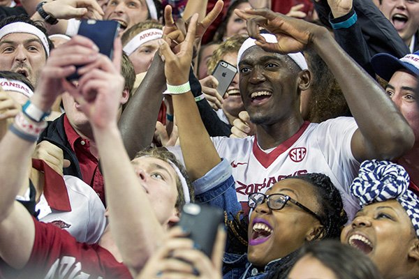 Arkansas forward Bobby Portis, right, celebrates and takes photos with students after his game-winning shot in overtime of an NCAA college basketball game against Alabama on Thursday, Jan. 22, 2015, in Fayetteville, Ark. Arkansas defeated Alabama 93-91. (AP Photo/Gareth Patterson)