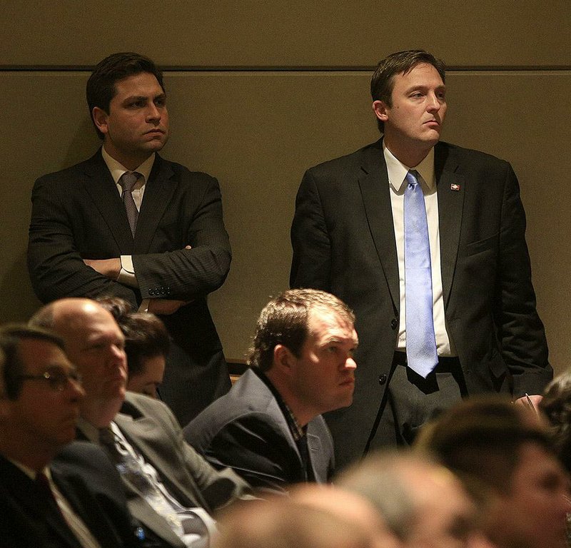 Arkansas Democrat-Gazette/STATON BREIDENTHAL --1/22/15--  Senate President Sen. Jonathan Dismang(left), R-Beebe, and House Speaker Jeremy Gillam (right) , R-Judsonia, listen as Gov. Asa Hutchinson speaks Thursday at the University of Arkansas for Medical Sciences in Little Rock about the private option along with the governor's chief of staff, Michael Lamoureux (seated middle). 

  