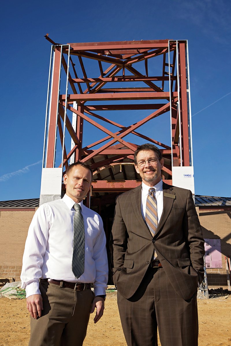 Andy Pennington, left, assistant principal at Vilonia Primary School, and Vilonia Superintendent David Stephens stand in front of the intermediate school under construction on Mount Olive Road. Pennington will be the principal of the school when it opens in fall 2015. The $13 million school had to be rebuilt after it was destroyed by a tornado in April, and Stephens said the school should be completed in June. The district will apply for a grant in hopes of building a separate safe room.