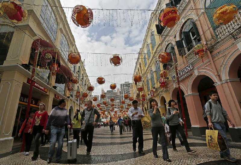 FILE - In this Feb. 1, 2014 file photo, tourists walk at the famous tourist spot Senado Square on the second day of the Chinese New Year in Macau. Macau was the world’s top-performing metro area in 2014, according to a report released Thursday, Jan. 22, 2015 by the Brookings Institution’s Metropolitan Policy Program as a part of the Global Cities Initiative, a joint project of Brookings and JPMorgan Chase.(AP Photo/Vincent Yu, File)