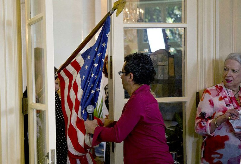 Workers bring in a second U.S. flag as they prepare the setting for a press conference by Assistant Secretary of State of the Bureau of Western Hemisphere Affairs Roberta S. Jacobson, at the official residence of the head of the U.S. Interests Section, in Havana, Cuba, Friday, Jan. 23, 2015. Shortly thereafter the flag was removed after it was determined that two U.S. flags was one too many. (AP Photo/Ramon Espinosa)