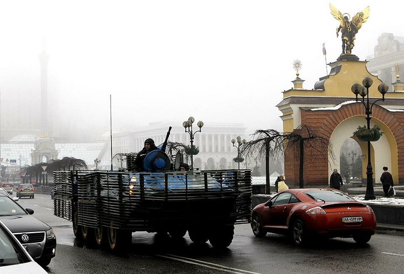 A Ukrainian military vehicle goes down the street on Independence Square in Kiev, Ukraine, Friday, Jan. 23, 2015.   Hours after a new peace initiative for Ukraine began taking shape, mortar shells rained down Thursday on the center of the main rebel-held city in the east, killing at least 13 people at a bus stop. (AP Photo/Sergei Chuzavkov)