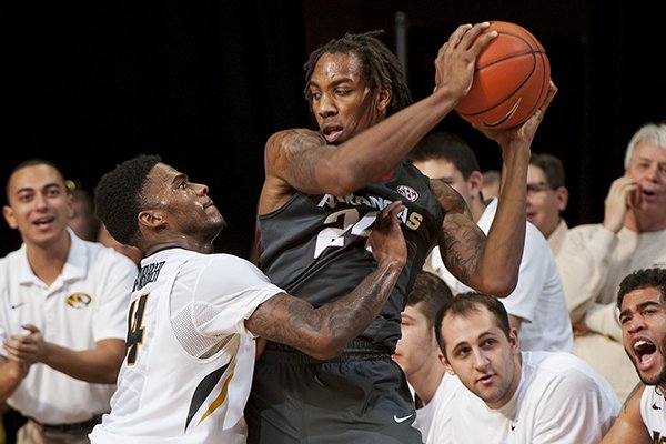 Arkansas' Michael Qualls, right, looks to pass as Missouri's Keith Shamburger, left, defends in front of the Missouri bench during the first half of an NCAA college basketball game Saturday, Jan. 24, 2015, in Columbia, Mo. (AP Photo/L.G. Patterson)