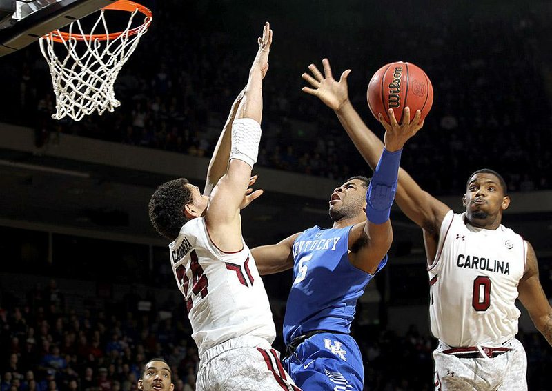Kentucky guard Andrew Harrison (5) attempts to split South Carolina defenders Michael Carrera (24) and Sindarius Thornwell (0) in the first half half of an NCAA college basketball game, Saturday, Jan. 24, 2015, at the Colonial Life Arena in Columbia, S.C. (AP Photo/Willis Glassgow)