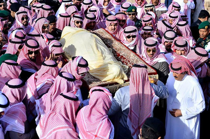 In this Friday, Jan. 23, 2015 photo, provided by the Saudi Press Agency, members of the Saudi royal family carry the body of King Abdullah, who died early Friday during his funeral in Riyadh, Saudi Arabia. In line with the strict interpretation of Islamic tradition observed in the kingdom, Abdullah was buried in an unadorned, beige cloth without a coffin in an unmarked grave. World leaders and top dignitaries began arriving in Saudi Arabia on Saturday, Jan. 24, 2015 to give their condolences following the death of King Abdullah at age 90  after nearly two decades at the helm. (AP Photo/SPA)