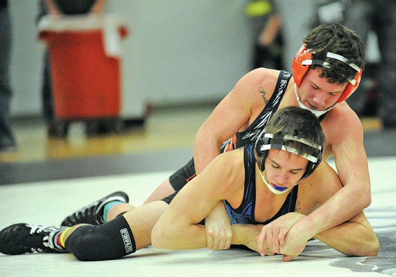 NWA Democrat-Gazette/ANDY SHUPE Caleb Royal of Rogers Heritage, top, and Grant Webb of Greenbrier wrestle Jan. 10 during competition in the Fayetteville Bulldog Invitational at Fayetteville High School. Royal won the 132-pound weight class in the tournament.