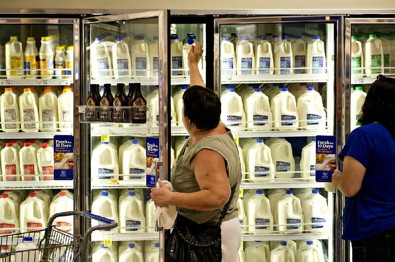 A shopper reaches for a jug of milk in a Kroger supermarket in Peoria, Illinois, U.S., on Tuesday, Sept. 10, 2013. The Kroger Co. is scheduled to report quarterly earnings on Thursday, Sept. 12. Photographer: Daniel Acker/Bloomberg