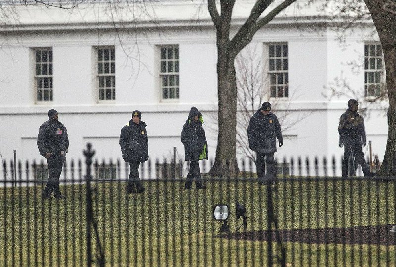 Members of the Secret Service search the grounds of the North Lawn of the White House in Washington, Monday, Jan. 26, 2015. A device, possibly an unmanned aerial drone, was found on the White House grounds during the middle of the night while President Barack Obama and first lady were in India. It was unclear whether their daughters, Sasha and Malia, were at home at the time of the incident with their grandmother, Marian Robinson. (AP Photo/Pablo Martinez Monsivais)