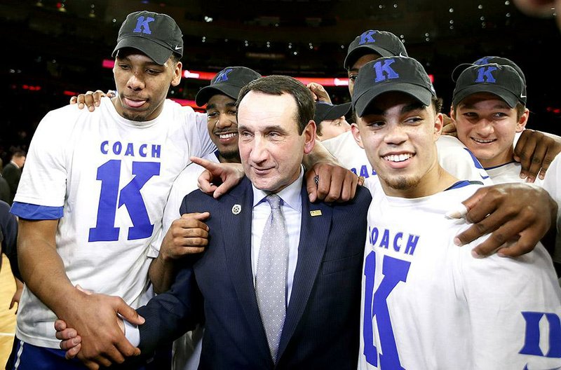 Duke head coach Mike Krzyzewski celebrates with his players after his 1,000th career win in an NCAA college basketball game against St. John's at Madison Square Garden in New York, Sunday, Jan. 25, 2015. Krzyzewski became the first men's coach in Division I history with 1,000 wins. (AP Photo/Kathy Willens)