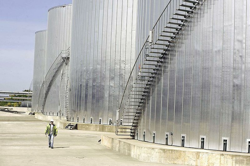 An employee walks near storage tanks at the Imperium Grays Harbor LLC biodiesel plant in Aberdeen, Washington, U.S., on Friday, May 15, 2009. 
The plant, opened in August 2007, is capable of producing 100 million gallons of biodiesel fuel from canola oil, soy and other crops. Photographer: Carlos Javier Sanchez/Bloomberg News