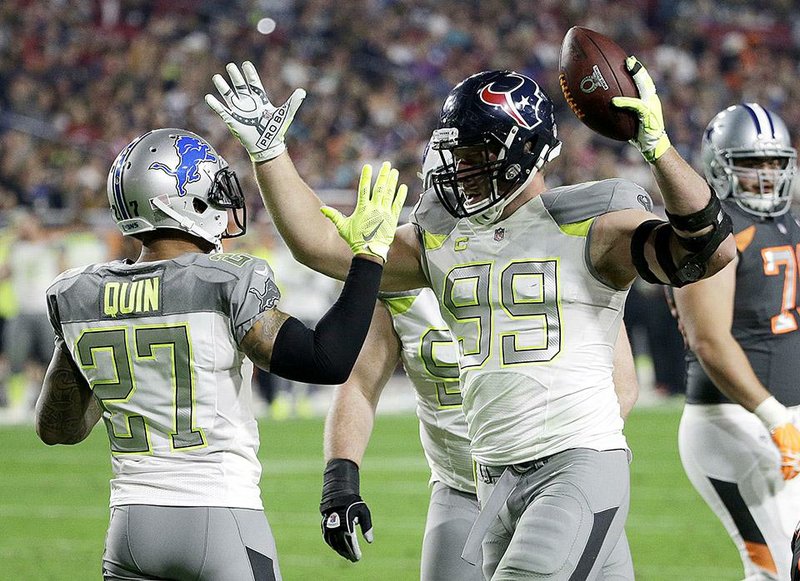 Houston Texans' J.J. Watt (99) is congratulated by Detroit Lions' Glover Quin after intercepting a pass during the first half of the NFL Football Pro Bowl Sunday, Jan. 25, 2015, in Glendale, Ariz.  (AP Photo/David J. Phillip)