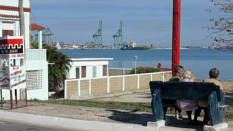 Special to the Arkansas Democrat-Gazette - 01/23/2015  - Cubans rest on a bench in the town of Mariel on Dec. 23, 2014. Across the harbor is a new container port that Cuba hopes will bring in needed hard currency. Mariel was made famous in 1980 when some 125,000 Cubans fled to the United States from the harbor in a massive boatlift. (Tim Johnson/McClatchy DC/TNS) 