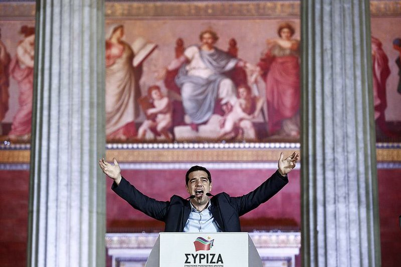 Leader of Syriza left-wing party Alexis Tsipras speaks to his supporters outside Athens University Headquarters, Sunday, Jan. 25, 2015. A triumphant Alexis Tsipras told Greeks that his radical left Syriza party's win in Sunday's early general election meant an end to austerity and humiliation and that the country's regular and often fraught debt inspections were a thing of the past. "Today the Greek people have made history. Hope has made history," Tsipras said in his victory speech at a conference hall in central Athens. (AP Photo/Petros Giannakouris)
