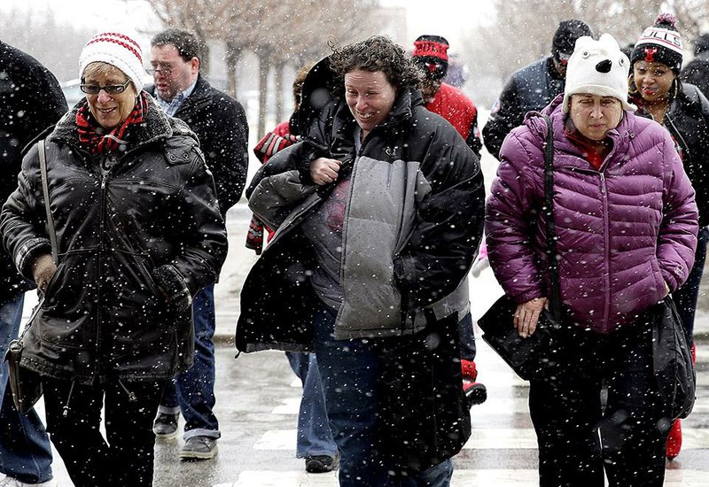 People walk through the snow on Sunday, Jan. 25, 2015, in Chicago. A storm system diving out of the Midwest has the potential to slowly coat from Philadelphia up to Massachusetts and Maine with snow beginning late Sunday night into Monday and intensifying greatly well into Tuesday, the National Weather Service said.  (AP Photo/Nam Y. Huh)