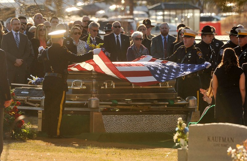 Members of the Rogers Police Department remove the flag from the casket of Rogers Police Chief James Allen Tuesday afternoon during his funeral service at the Bentonville Cemetery in Bentonville.